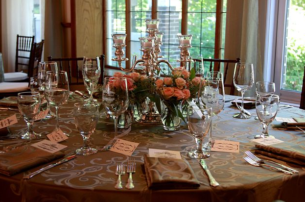 Silver candelabras surrounded by sweet arrangements of peach roses with 