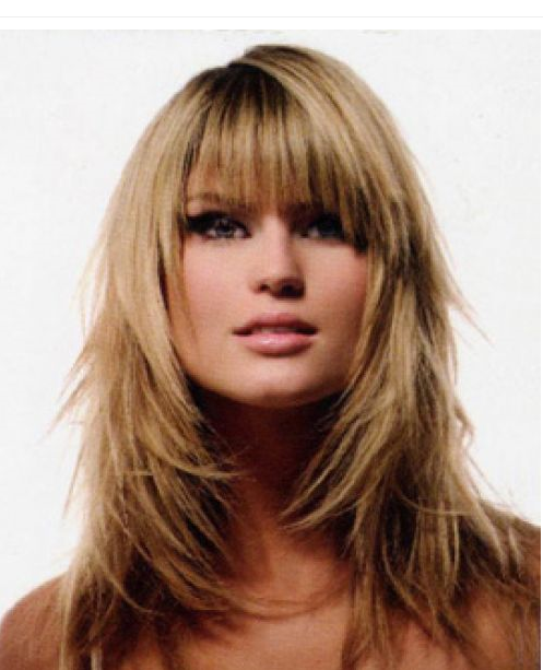 woman with shoulder length blond layered hair and bangs