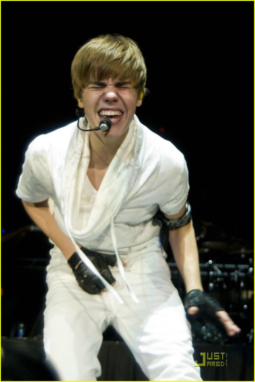 Justin Bieber reaches out into the crowd to his fans as he performs at the 