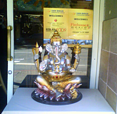 Seated Ganesha on a table covered with white table cloth.