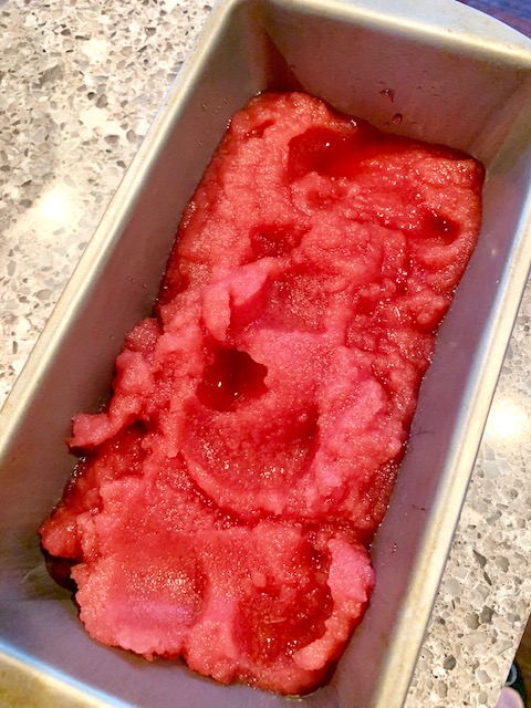 Bright pink pomegranate sorbet in a loaf pan.