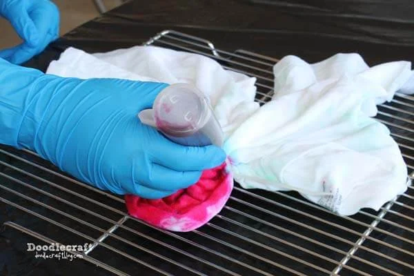 Step 3: Tie Dye Time   Wear gloves, work over plastic on a drying rack. Gently squeeze out the dye in each zip tied section of the shirt. (This is a picture to show the process, not the actual shirt)
