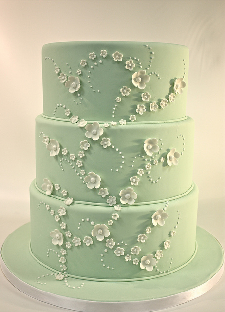 Gorgeous classic style wedding cake in white and pastel green set over three