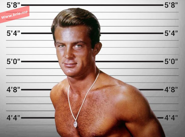 A young Robert Conrad posing in front of the height chart