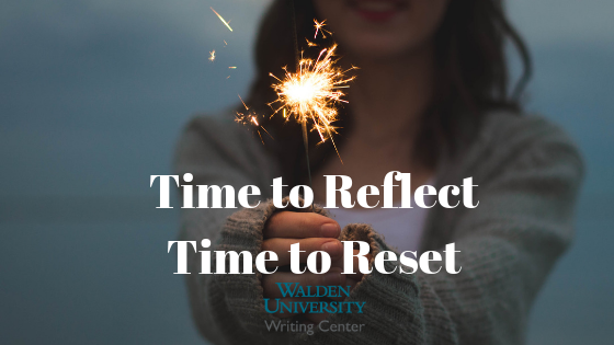 Image of woman holding sparkler with text: "Time to reflect; time to reset"