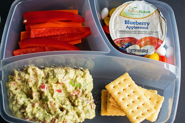 A picture of the lunch box with the tuna salad, crackers, carrot sticks, and apple sauce.