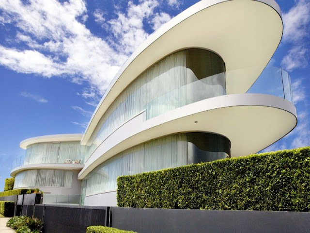 Modern house and the curvy facade as seen from the sidewalk