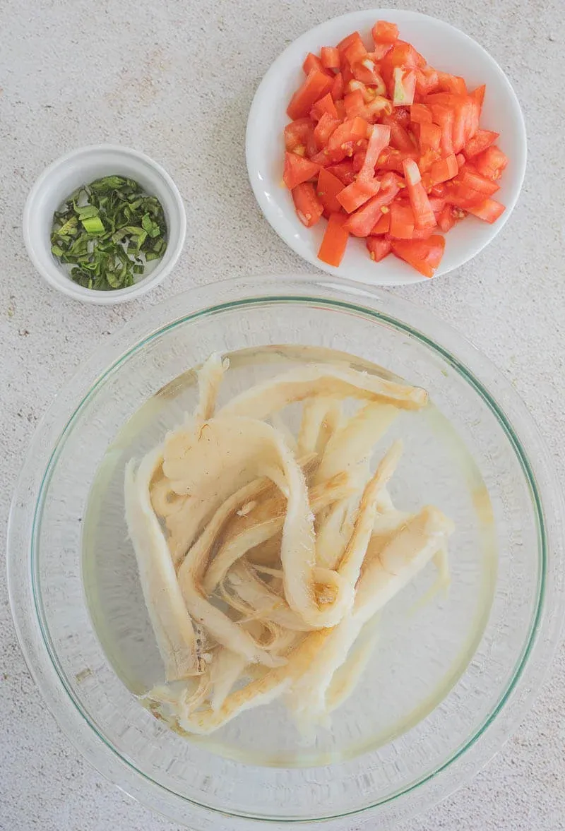 Showing saltfish in a bowl of water soaking to rehydrate before use.