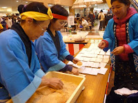 搗き上がった餅に黄な粉をまぶす・・・