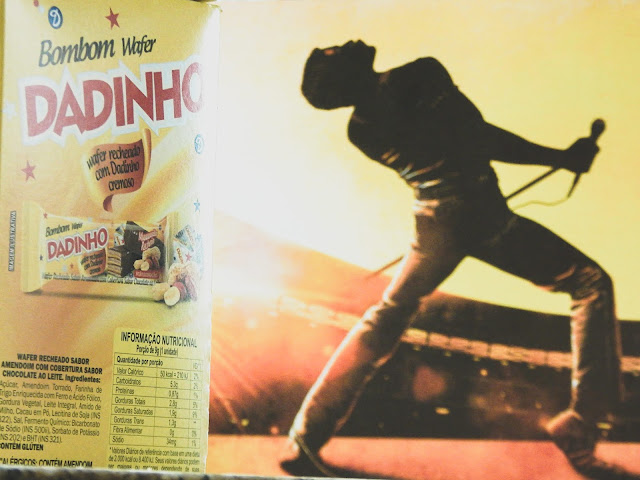 Caixa de Bombom Dadinho ao lado de quadro de Freddie Mercury