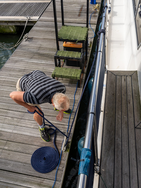 Photo of Phil adjusting Ravensdale's mooring ropes as the water level drops
