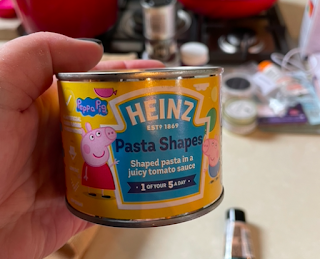 A picture of me holding a tin of Heinz Pasta Shapes, with a Peppa Pig theme.