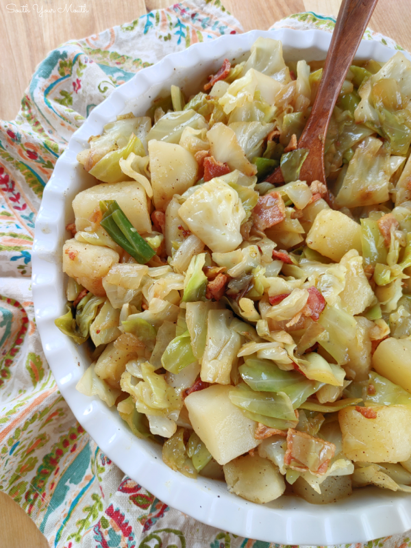 Southern-Style Smothered Cabbage & Potatoes! A simple homestyle recipe for tender potatoes smothered in fried cabbage and onions cooked with bacon.