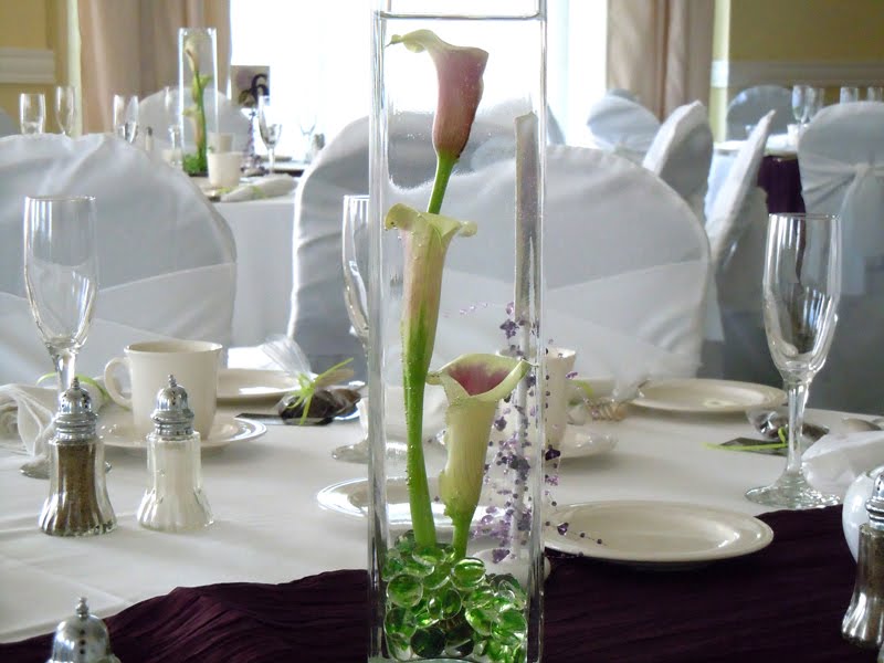 centerpiece of picasso calla lilies in a square glass vase