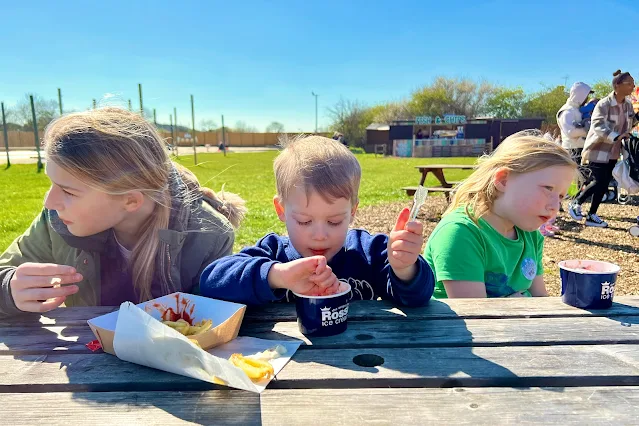 3 children at a picnic bench eating Rossi Ice Cream and chips