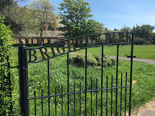 The gate to Brighton Park with the name inscribed in it and the grassy field behind it.