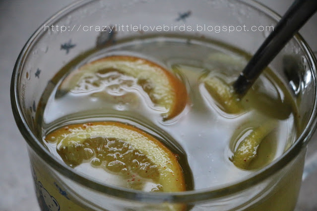 Hot drink inside of cup with sliced oranges