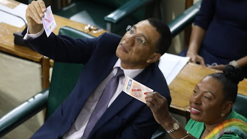 Prime Minister Andrew Holness and Cabinet colleague Olivia Grange recently examine samples of the new polymer Jamaican banknotes that have since gone in circulation nationally.