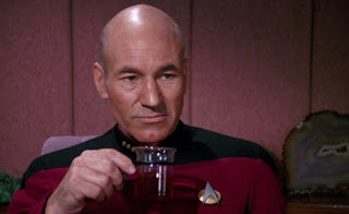 Captain Picard holding a cup of tea and staring into the middle distance