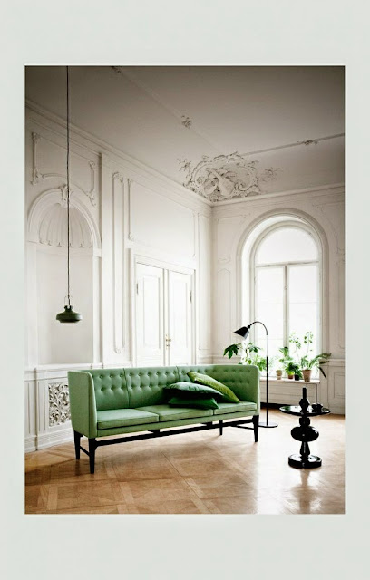 large open and  airy white living room with green velvet sofa