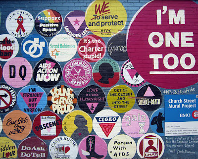 Image of a part of a mural showing different Pride buttons, from the LGBT Archive