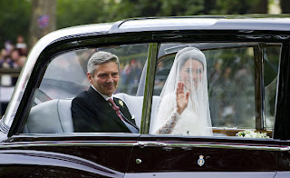 Kate Middleton waves as she travels in a Rolls Royce Phantom VI, accompanied by her father Michael Middleton to Westminster Abbey.