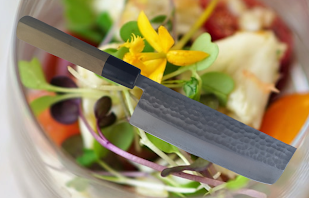 Foreground: Japanese knife. Background: crisp, fresh salad.