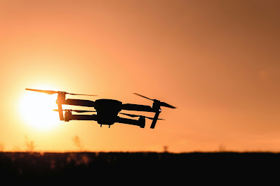 Silhouette of a drone against a warm sunset sky, symbolizing the future of aerial LiDAR technology. The drone's compact form factor highlights the trend towards miniaturization and integration, suggesting advancements that will allow such technology to become more accessible and versatile. This image captures the potential of smaller, more efficient LiDAR systems to revolutionize data collection, especially in challenging terrains, reflecting a future where aerial LiDAR's applications are as broad and far-reaching as the horizon itself.