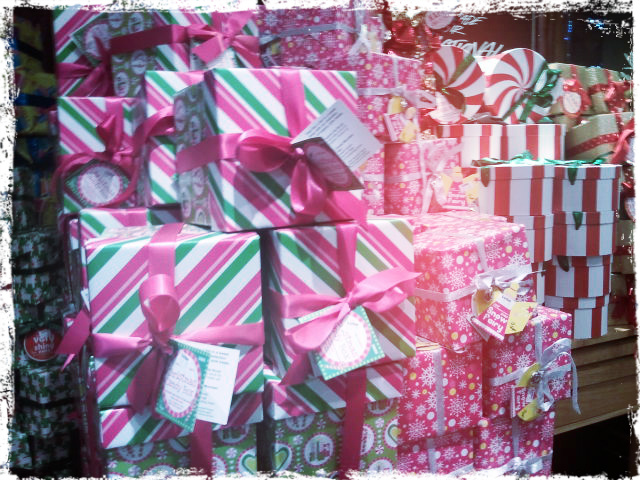 pink and green striped boxes tied with pink ribbon piled high