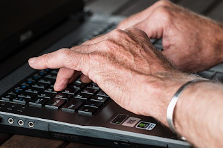 An elderly man using a laptop