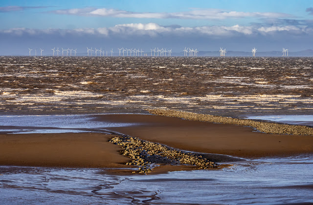 Photo of Maryport shore with Robin Rigg wind farm in the distance