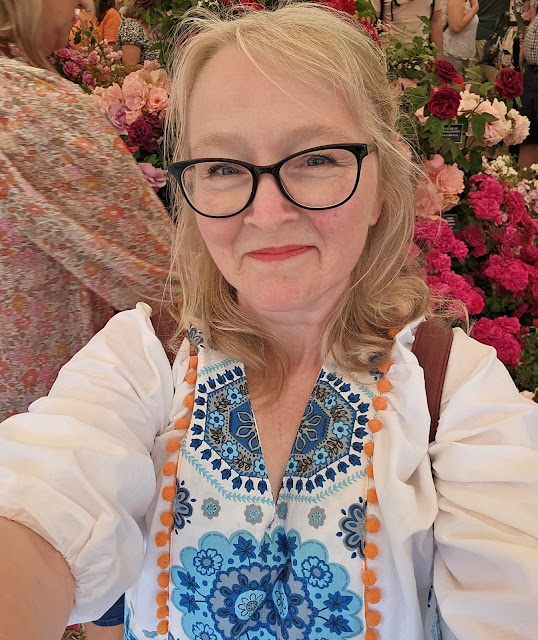 Top half of white woman in white and turquoise dress