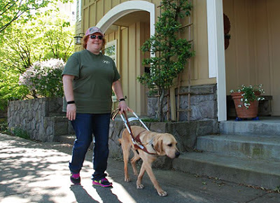 Laura Ann Grymes and guide dog Dyson walk down the street
