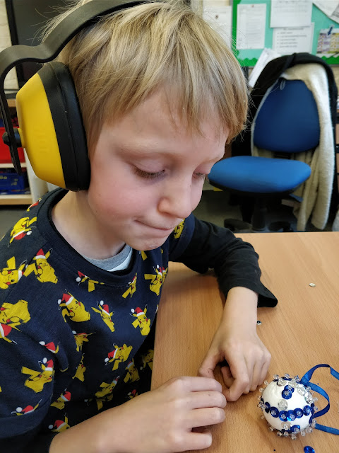 child with autism wearing ear defenders and pikachu t shirt