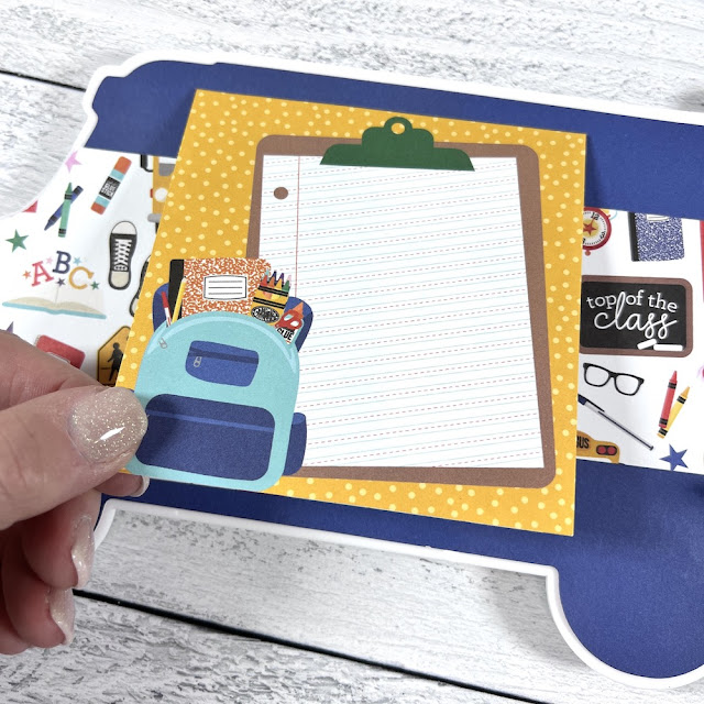 School Bus shaped scrapbook album page with a backpack, clipboard, and school supplies