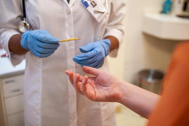 A doctor handing medication to a patient.