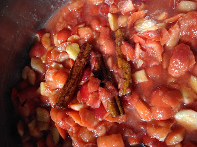 A pan full of crab apples, simmering in their own juices. Cinnamon sticks in the middle. 