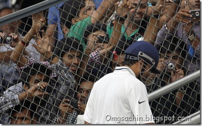 India's Sachin Tendulkar leaves the field as fans try to take pictures of him after the third day of their third test cricket match against West Indies
