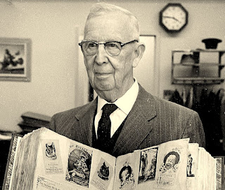 Earl J. Arnold holding his mother Emma Jane Arnold's 19th century trade card scrapbook