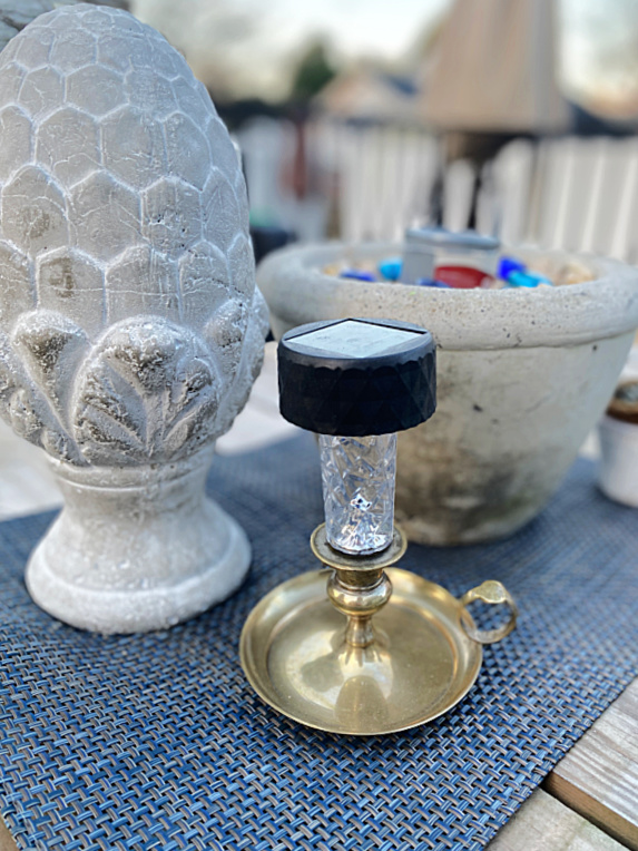 brass candlestick with solar light and cement decor