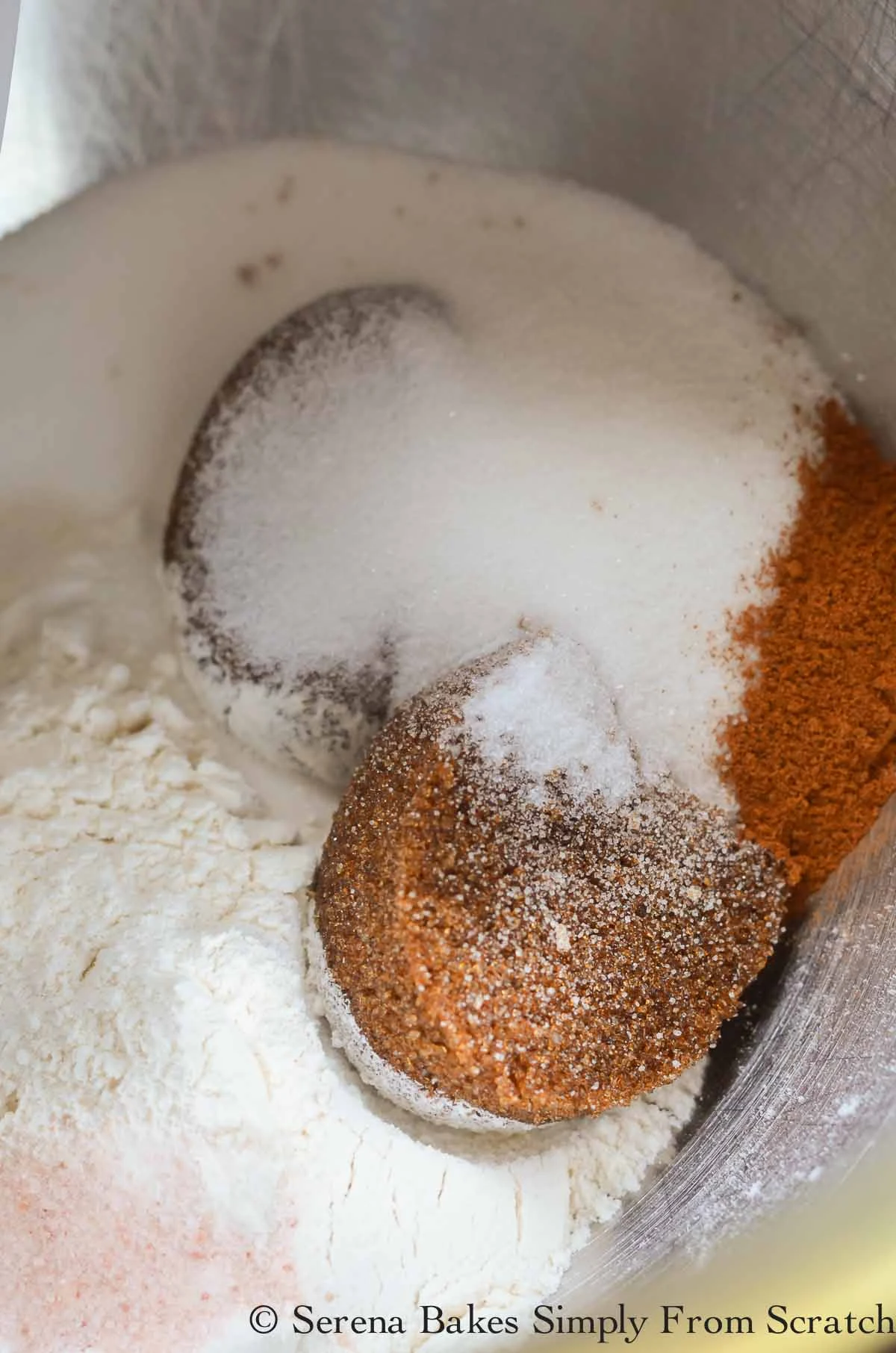 A mixing bowl filled with all-purpose flour, dark brown sugar, granulated sugar, salt and cinnmon.