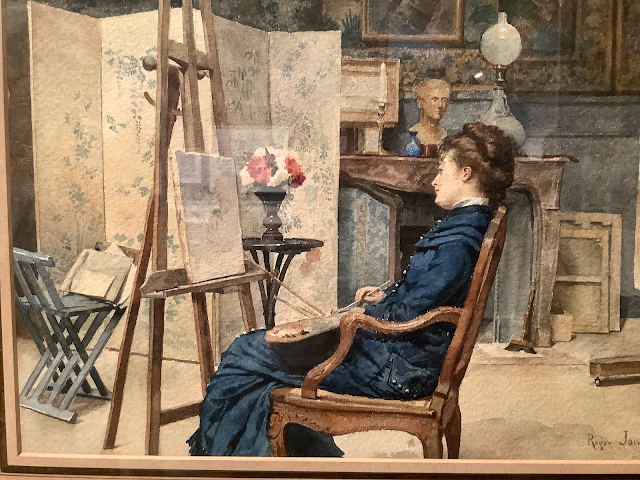 Artist’s studio where woman looks at her painting