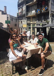 seis pessoas em uma mesa numa rua histórica do Porto