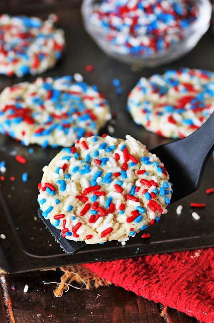 Removing Red White & Blue Sprinkle Sugar Cookie from Baking Sheet with a Spatula Image