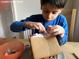 Boy decorating a gingerbread house