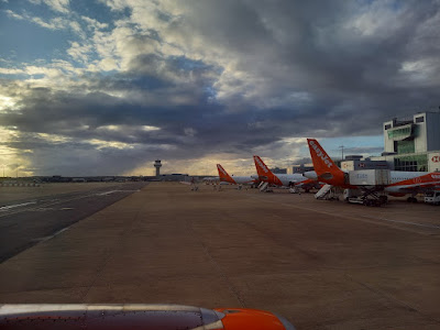 Luchthaven, bewolkte lucht en staarten van vliegtuigen