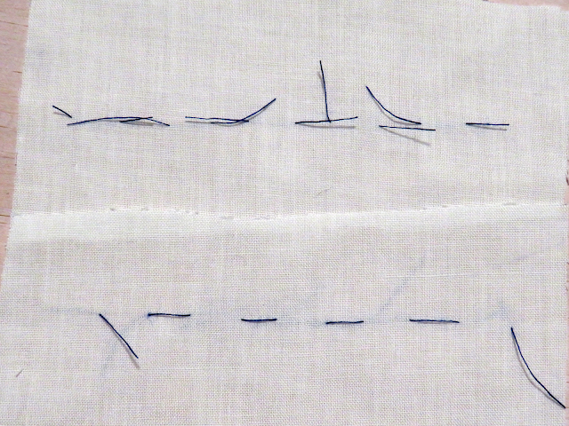 Punto flojo cortado con hilo azul sobre tela blanca
