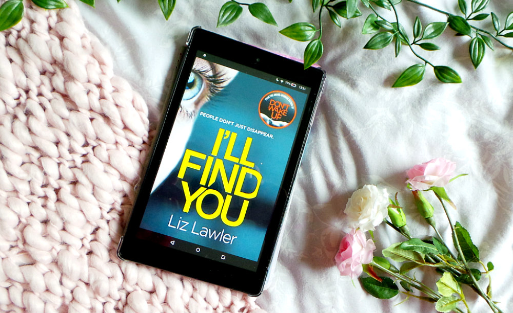 kindle fire with the I'll Find You cover showing. Its resting on a pink chunky knit blanket next to 3 roses