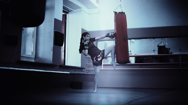 Woman practicing martial arts, heavy bag, punching bag, muay thai