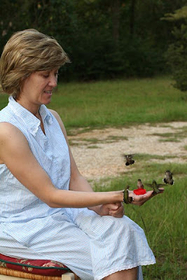 woman feeding hummingbirds